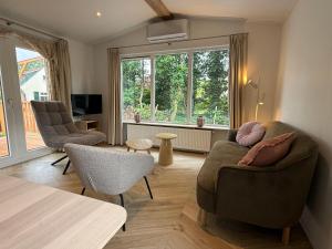 un salon avec deux chaises et un canapé dans l'établissement Luxe chalet op 5-sterren camping-4P-ruime veranda-2 fietsen, à Sevenum