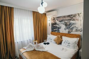 a bedroom with a bed with towels on it at Centru Est One in Drobeta-Turnu Severin