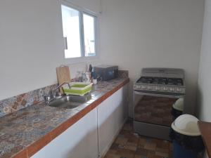 kuchnia ze zlewem i kuchenką w obiekcie Casa Villa NOA w mieście Puerto Escondido