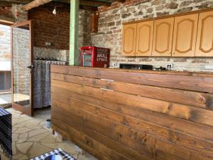 a wooden bar in a kitchen with a brick wall at Boutique Vila ERI in Gjirokastër