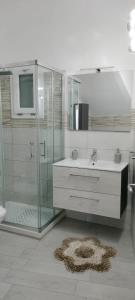 ein Badezimmer mit Glasdusche und Waschbecken in der Unterkunft Daisy House in Siculiana