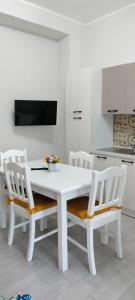 eine weiße Küche mit einem weißen Tisch und Stühlen in der Unterkunft Daisy House in Siculiana