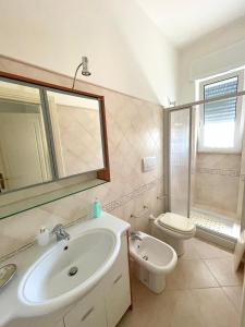 a bathroom with a sink and a toilet and a mirror at Villa Oleandera a Polignano a Mare in Polignano a Mare +30 photos