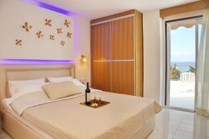 1 dormitorio con 1 cama y vistas al océano en Kastoria Hotel Apartments, en Chaniotis