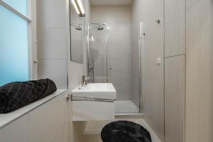 a white bathroom with a sink and a shower at Riverside N22 in Prague +31 photos