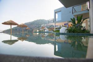 Una piscina de agua con sombrillas en la parte superior de un edificio. en Hotel Hyalma Cliff - Adults Only, en La Herradura