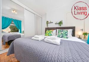 a bedroom with a large bed with towels on it at Nicol Apartment by Klass Living Airdrie in Airdrie