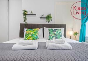 a bedroom with a large bed with two pillows at Nicol Apartment by Klass Living Airdrie in Airdrie