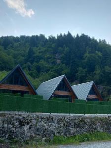 a group of three houses with green roofs at Tozkaban Bungalow in Çamlıhemşin +7 photos