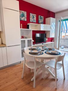 a kitchen with a white table and chairs and red walls at Casa al Mare WiFi Ac in Chioggia