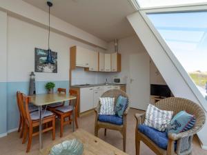 a kitchen and dining room with a table and chairs at Dorpsplein 23E apartment in Callanstoog square in Callantsoog +6 photos