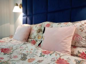 a bed with two pillows and a blue head board at APART PARK -Lividus112 in Świnoujście