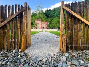 a wooden gate with a fence in front of a house at Hotel Canudos in Kutaisi