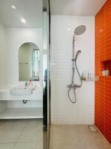 une salle de bain avec douche et lavabo dans l'établissement Le Ciel Phu Quoc - Hillside Apartment, à Duong Dong