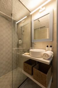 a bathroom with a sink and a glass shower at Potnia in Limín Khersonísou