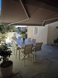 Una mesa y sillas de madera en un patio. en Villa Cevalia, en Balaruc-les-Bains