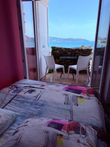 a bedroom with a bed and two chairs and a table at Sea Apartment Igalo in Herceg-Novi
