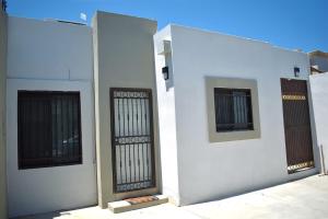 two gates on the side of a white building at House equipped with two bedrooms in La Paz