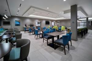 a dining room with tables and chairs in a restaurant at TownePlace Suites By Marriott Wrentham Plainville in Wrentham