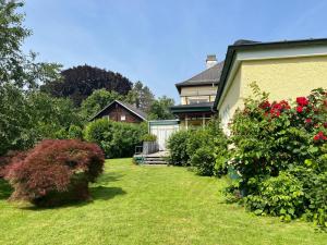 a yard with a house and some bushes and flowers at Apartment am Stadtpark in Vöcklabruck