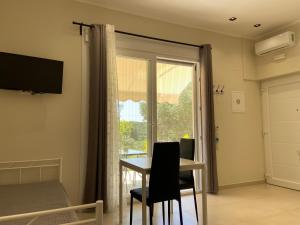 a room with a table and chairs and a window at Catherine's Studios Sivota in Syvota