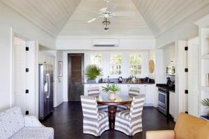 a kitchen with a table and chairs and a ceiling at French Leave Resort, Autograph Collection in Governorʼs Harbour