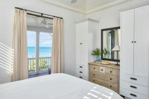a bedroom with a bed and a view of the ocean at French Leave Resort, Autograph Collection in Governorʼs Harbour