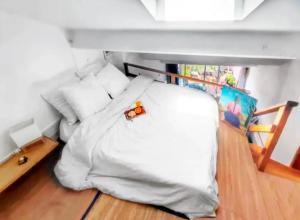 ein Schlafzimmer mit einem weißen Bett und einem Spielzeug darauf in der Unterkunft Appartement contemporain à La Seyne-sur-Mer, 30 m², terrasse in La Seyne-sur-Mer