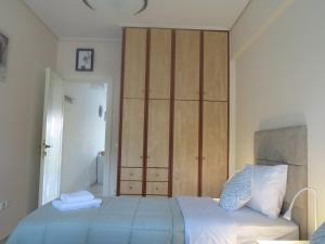 ein Schlafzimmer mit einem Bett und einem großen Holzschrank in der Unterkunft ELIRA - City Apartment, Lefkada in Lefkada Town