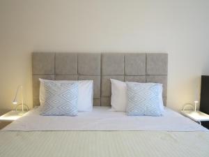 ein Bett mit zwei Kissen und einem Kopfteil in der Unterkunft ELIRA - City Apartment, Lefkada in Lefkada Town