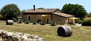 a house with large tires in front of a yard at Casa Farfaglia in Noto