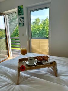 a tray with croissants and a drink on a bed at OdpocznieszTU in Brzozowa