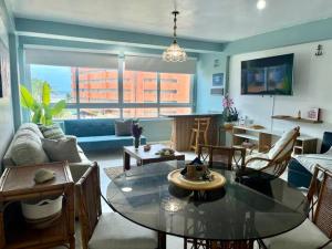 een woonkamer met een glazen tafel en een bank bij Beach apartment in La Mar Suites, Tucacas Venezuela in Tucacas
