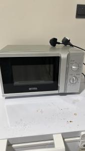 a silver microwave sitting on top of a counter at فيلا مطله in Muqammar