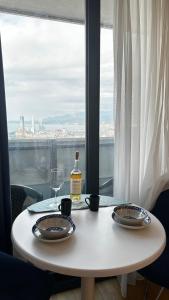 a white table with two plates and a bottle of wine at BEST VIEW APARTMENTS ORBI CITY D1 BLOCk in Batumi +31 photos