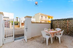 eine Terrasse mit Tisch und Stühlen und einem Zaun in der Unterkunft Dimora Lucy by Vivimy in Taviano + 18 Fotos