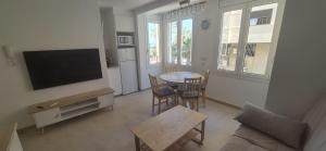 a living room with a table and a television at Vinaros Beach in Vinarós