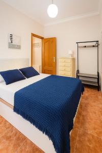 Un dormitorio con una cama grande con una manta azul. en Alhambra Boqueron 2, en Granada