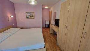 a bedroom with a bed and a dresser with a television at Dijana in Makarska