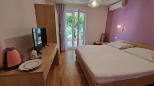 a bedroom with a large bed and a television at Dijana in Makarska