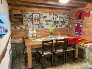 a dining room with a wooden table and chairs at Каменната къща in Borowo