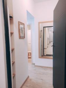 - un couloir avec un miroir dans une chambre blanche dans l'établissement Good vibes apartment in center, à Bratislava 5 autres photos