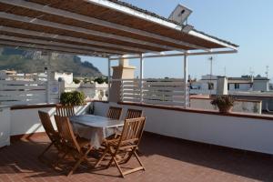 Un patio con una mesa y sillas en un tejado. en Casa vacanza Annameri, en Terrasini