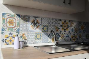 Una cocina con fregadero y azulejos en la pared. en Casa vacanza Annameri, en Terrasini