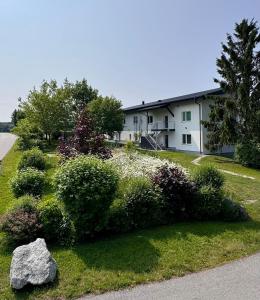 a house with a yard with bushes and a rock at Bergland Top 4-1 in Petzenkirchen