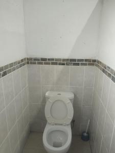 a bathroom with a white toilet in a tiled room at Melee's house in Richards Bay