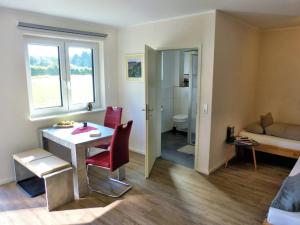 a small living room with a table and a couch at Hempen Fied Gästehaus - Apartment 4 in Bad Zwischenahn +27 photos