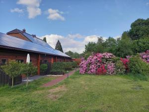 a garden with pink flowers next to a building at Hempen Fied Gästehaus - Apartment 4 in Bad Zwischenahn