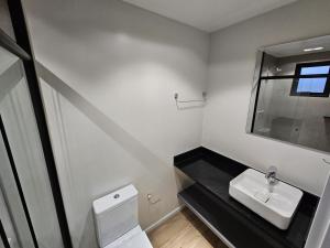 Un baño con un inodoro blanco y un lavabo. en You Hotéis Inteligentes Tubarão, en Tubarão