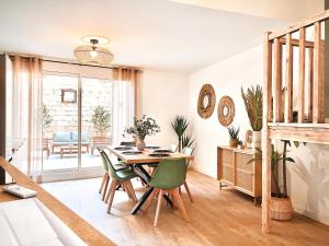 a dining room with a table and green chairs at Le Tourmaline Duplex in Saint-Paul-Trois-Châteaux